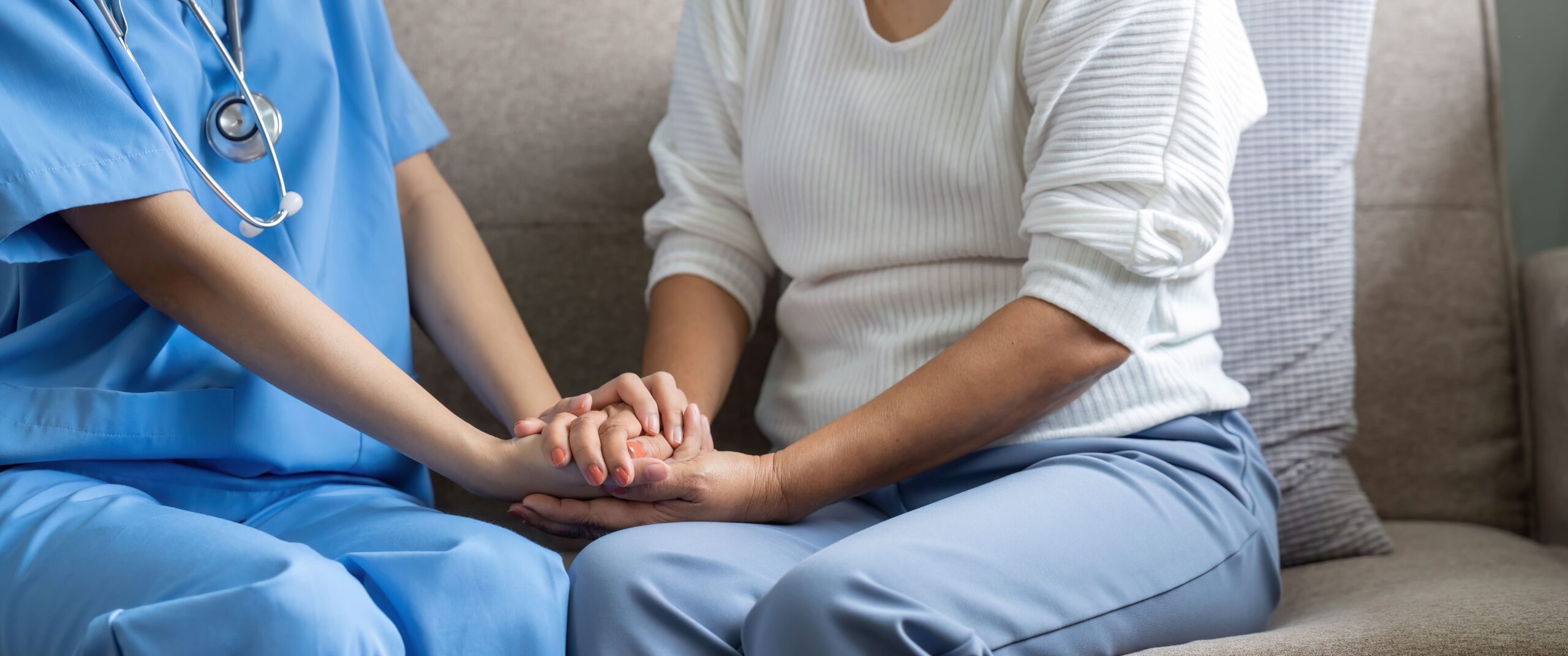 un'infermiera che stringe la mano ad una persona anziana